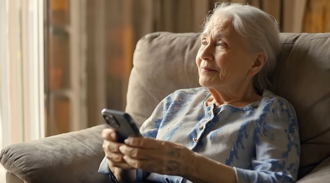 Elderly woman holding a phone, ready to call